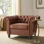 Fauteuil club Chesterfield Zeus et Ruta avec accoudoirs volutes, garniture cloutée et pieds en bois massif